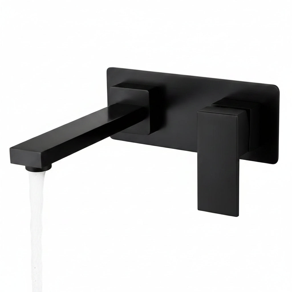 Modern matte black wall-mounted basin mixer tap with running water in a luxury minimalist bathroom featuring natural stone textures and warm sunlight.