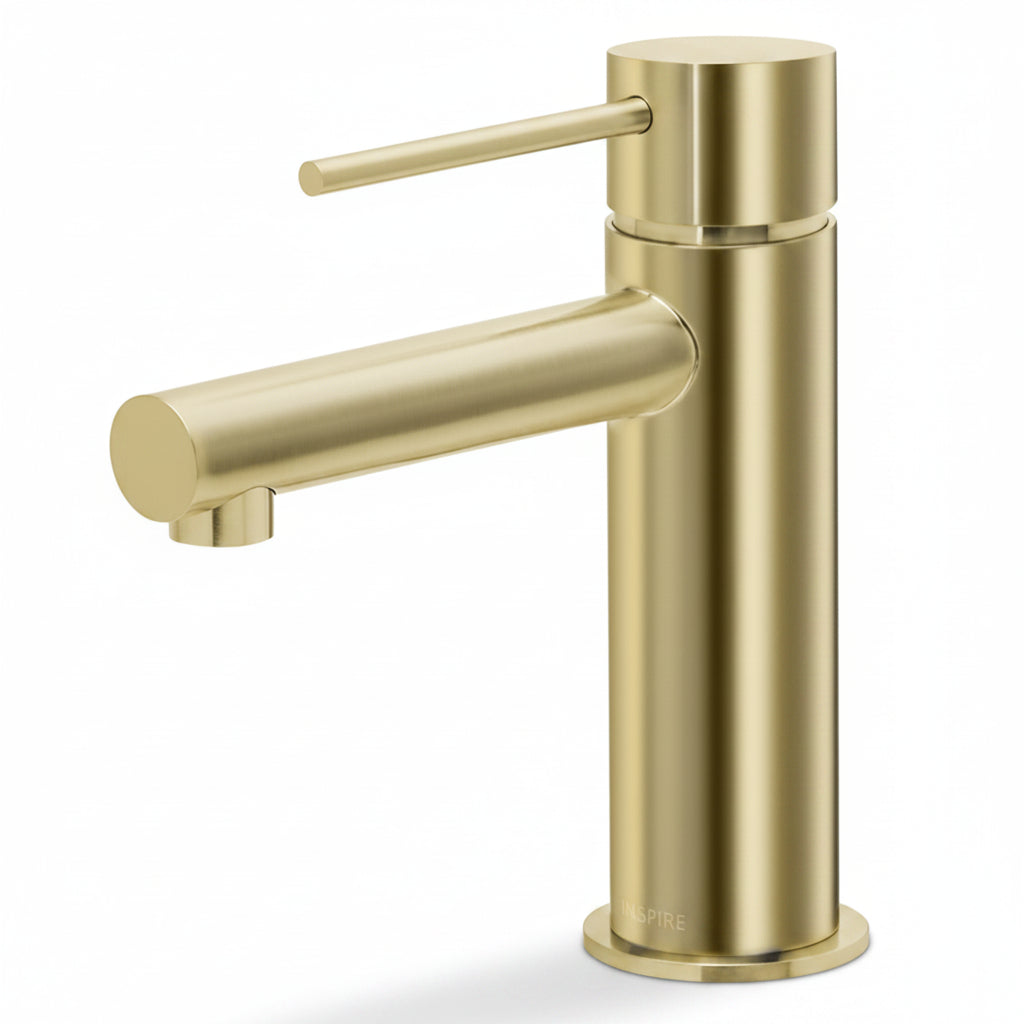 Luxury brushed brass basin mixer with soft natural shadows and warm modern bathroom styling